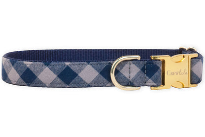 A stylish navy plaid dog collar with metal hardware and an engraved buckle, blending everyday durability with upscale charm for the pup who likes to strut in style.