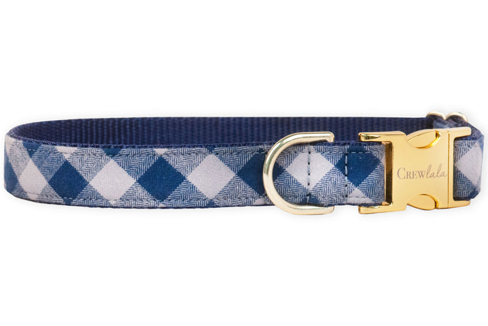 A stylish navy plaid dog collar with metal hardware and an engraved buckle, blending everyday durability with upscale charm for the pup who likes to strut in style.