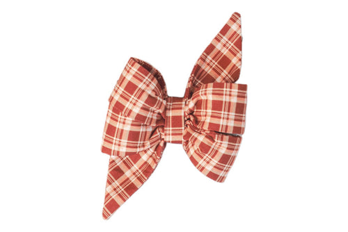 A feminine belle bow made from red plaid fabric, featuring voluminous pleats and pointed ends. The attachable belle bow is symmetrical and structured.