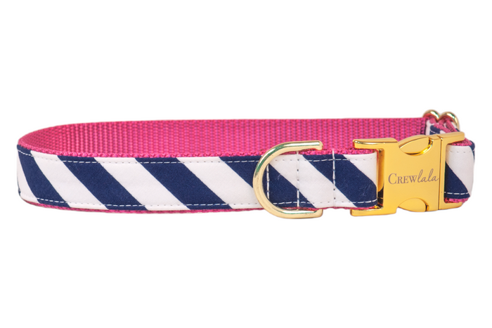 Stylish dog collar with a nautical or Americana vibe, showcasing diagonal navy and white stripes on cotton fabric, paired with a vibrant pink inner webbing. The collar is finished with sleek silver-tone hardware, including a durable D-ring and engraved clasp for a polished, functional look.